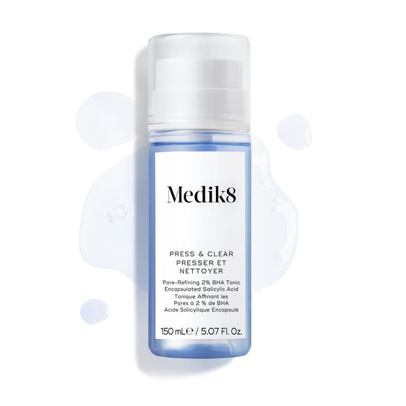 Frasco de 150 mL do Medik8 Press & Clear apresentado sobre um fundo branco, com salpicos de tónico azul à sua volta.-19