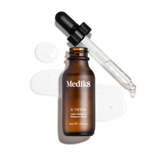 Frasco de sérum Medik8 castanho com conta-gotas sobre fundo branco
