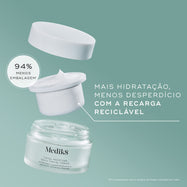 Uma vista desconstruída do frasco do creme Medik8 Total Moisture Daily Facial Cream sobre um fundo verde-azulado. A tampa flutua sobre uma recarga reciclável branca cheia de creme, posicionada acima do frasco de vidro principal. O texto destaca a recarga reciclável com "94% menos embalagem" e "Mais hidratação, menos desperdício."