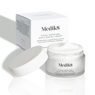 Um boião aberto de Total Moisture Daily Facial Cream juntamente com a sua embalagem de cartão branca.