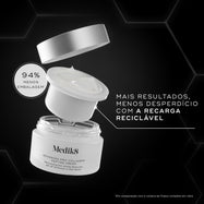 Contra um fundo cinza escuro hexagonal, é exibida uma decomposição de produto em estilo de explosão do Medik8 Advanced Pro-Collagen+ Peptide Cream. Uma tampa prateada flutua acima de uma cápsula de recarga branca aberta, que está sendo baixada para o frasco de vidro principal. O texto branco ao lado destaca o conceito de recarga reciclável e observa "94% menos embalagem" em um balão circular. O texto na parte inferior compara com a compra de um frasco de vidro completo.