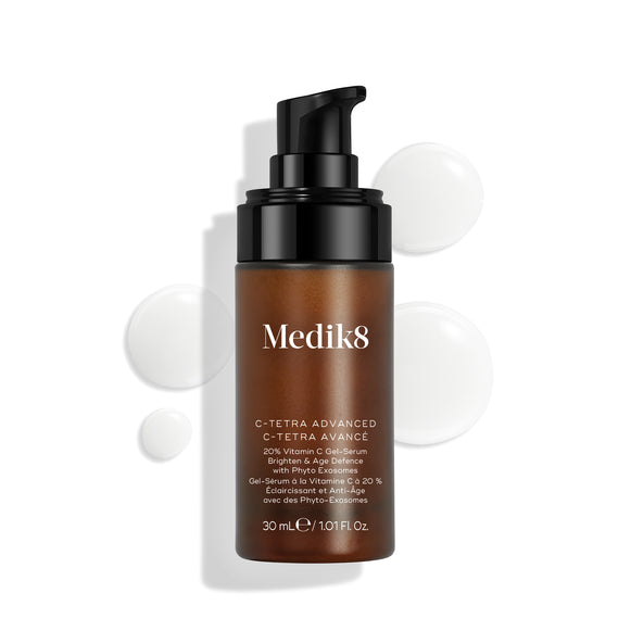 Frasco do Medik8 C-Tetra Advanced apresentado sobre um fundo branco limpo, com gotas de sérum translúcidas, destacando a sua textura leve de gel-sérum.-5