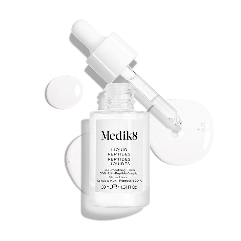 Frasco de vidro transparente com conta-gotas do sérum Liquid Peptides, apresentado com a pipeta removida e colocada ao lado, juntamente com gotas de sérum, destacando a sua textura.