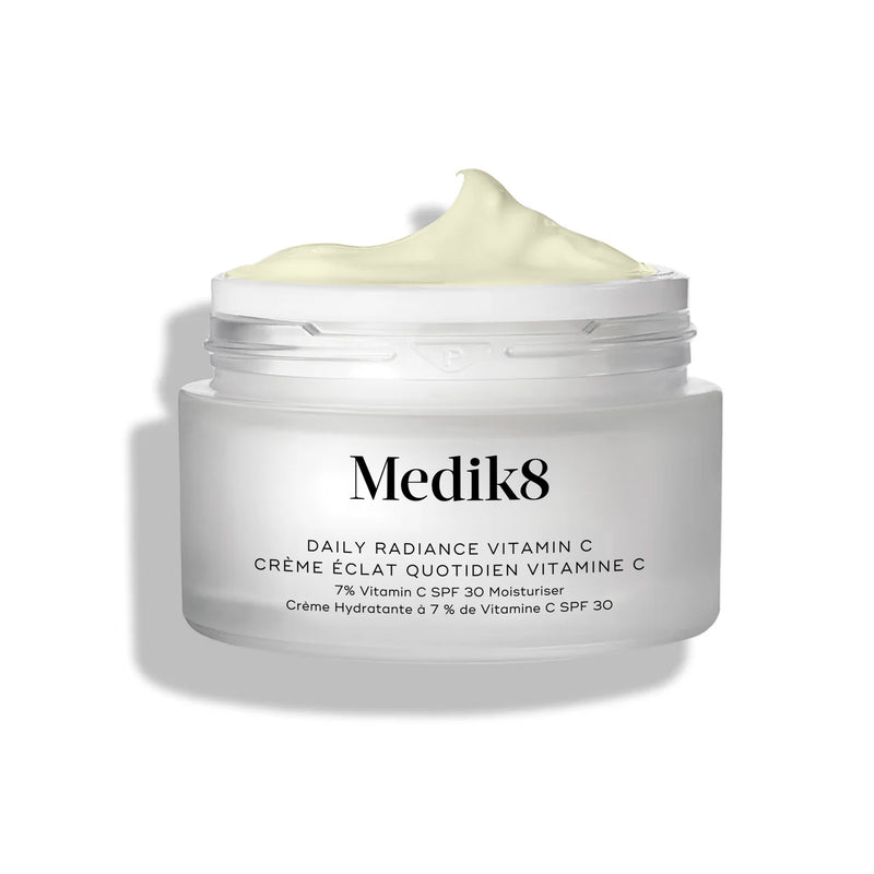 Frasco de vidro do creme Medik8 Daily Radiance Vitamin C aberto, com uma generosa quantidade de creme amarelo-claro em relevo no topo.