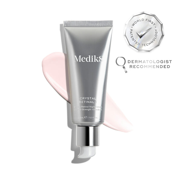 O tubo do sérum Medik8 Crystal Retinal 1 é exibido sobre um fundo branco limpo com uma grande amostra de creme pêssego. Selos prateados à direita destacam "Tecnologia Patenteada Pioneira no Mundo" e "Recomendado por Dermatologistas". O texto no tubo identifica-o como um sérum noturno de retinal estável com vitamina A de força suave.-4